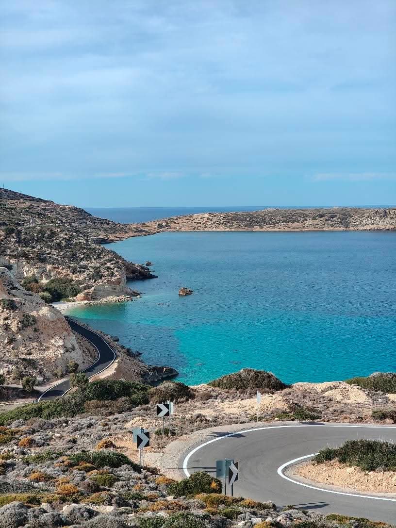 Turquoise cove and winding road on the east coast near Papadiokampos, Sitia, Crete