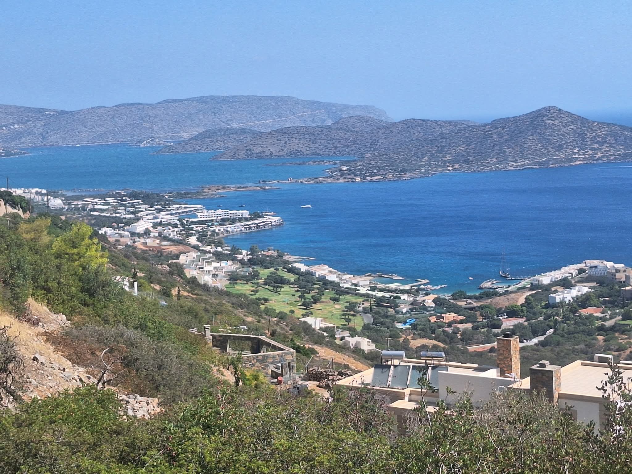 Baie d'Elounda vue des hauteurs : villas à flanc de colline, resorts et presqu'île de Spinalonga, Crète