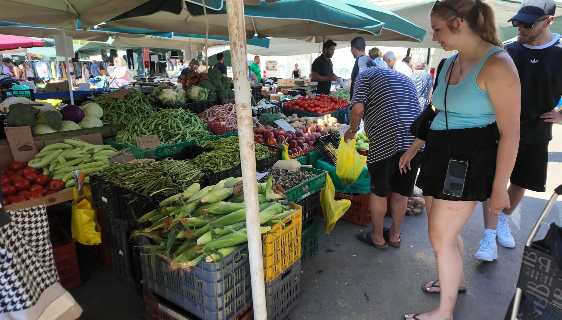 Vegetable stall at the Nea Chora laiki agora: courgettes, green beans, cauliflowers, corn and tomatoes, with prices handwritten on cardboard