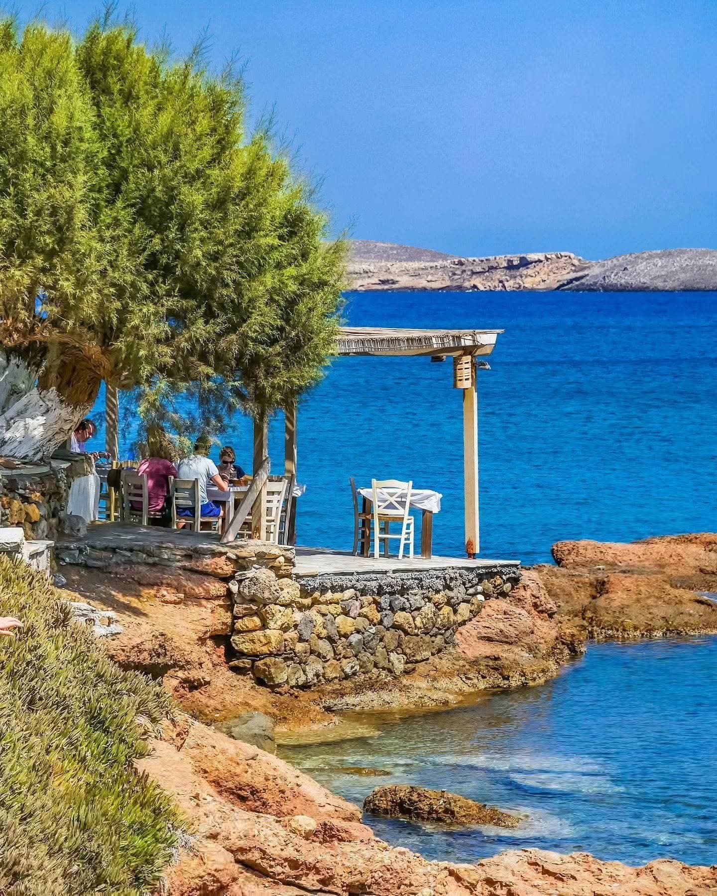 Taverna terrace on the rocks by a blue sea near Sitia, Crete