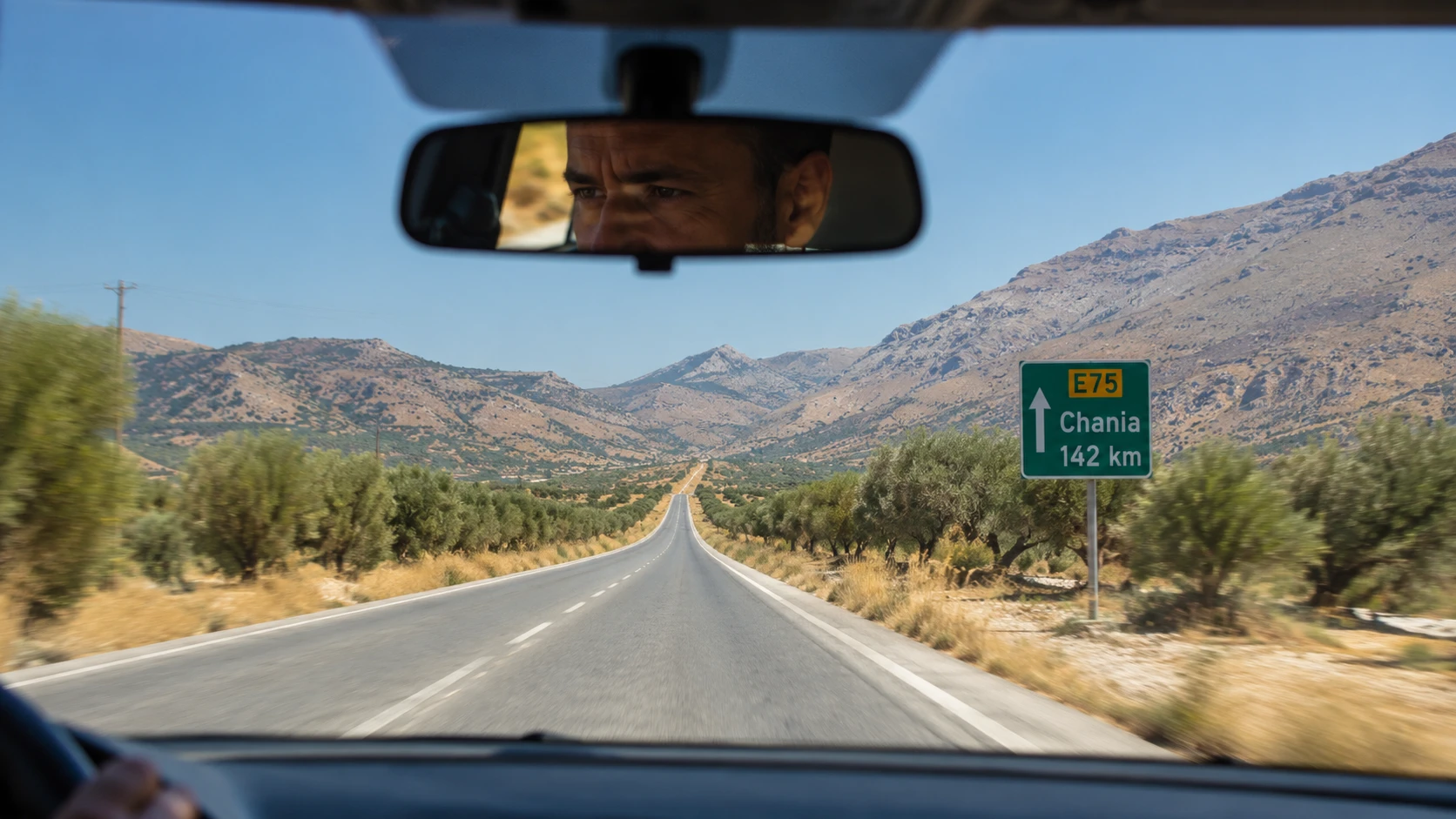 Panneau routier sur l'autoroute crétoise indiquant les distances entre La Canée et Héraklion — la réalité des 260 km de l'île